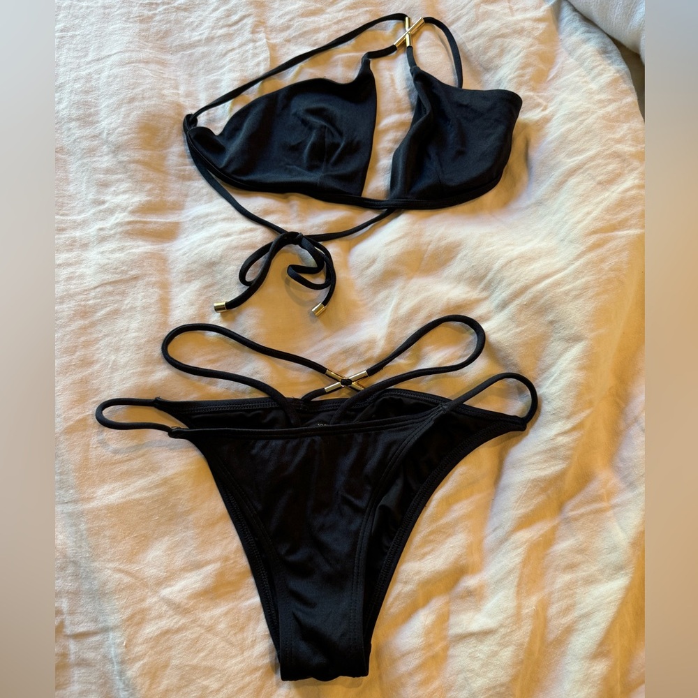 Victoria’s Secret sexy black bathing suit with straps and gold details.